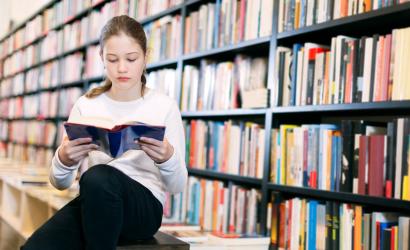 dziewczyna czyta książkę w bibliotece