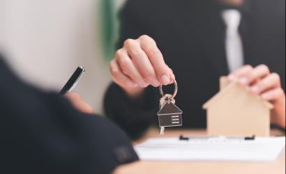 Agent broker trzymający domowy brelok do kluczy obsługuje dokumenty biznesowe i umowy podpisywanie umów biznesowych współpraca biznesowa podpisywanie handlowe podpisywanie umów umowa zakupu nieruchomości