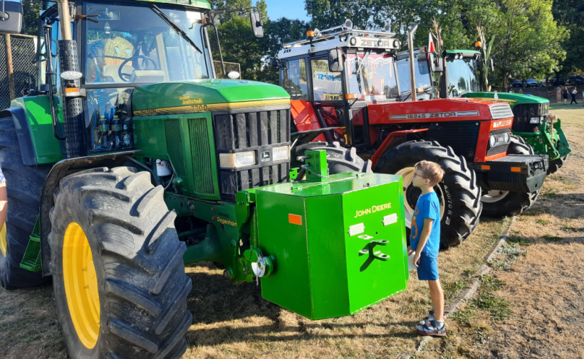 mały chłopczyk podziwia ogromny traktor