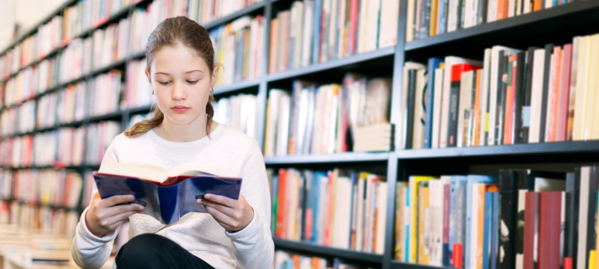 dziewczyna czyta książkę w bibliotece