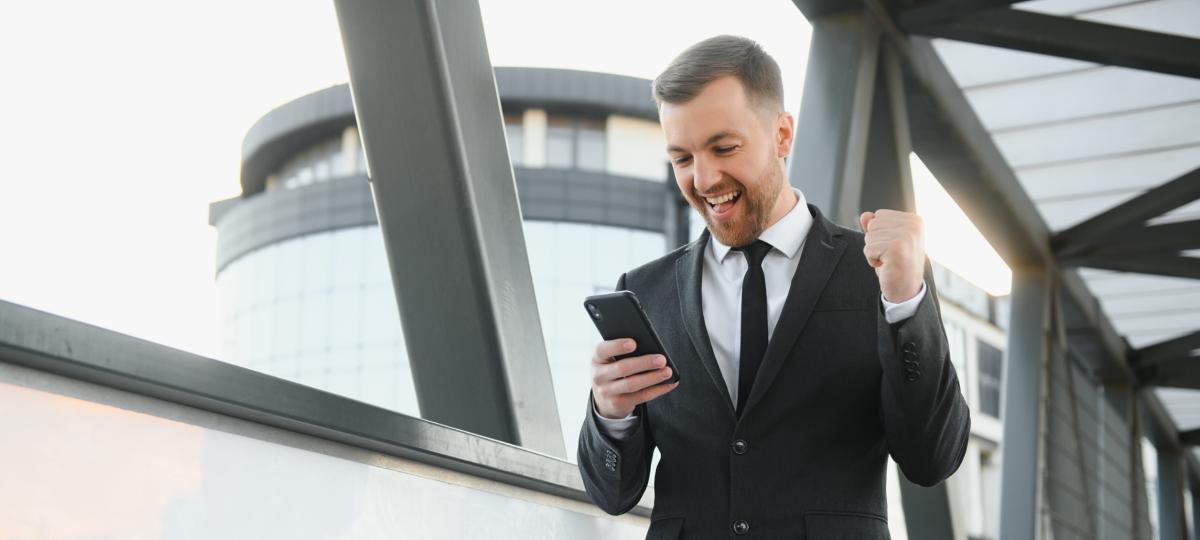 Młody mężczyzna ubrany formalnie, cieszący się koncepcją zwycięzcy sukcesu