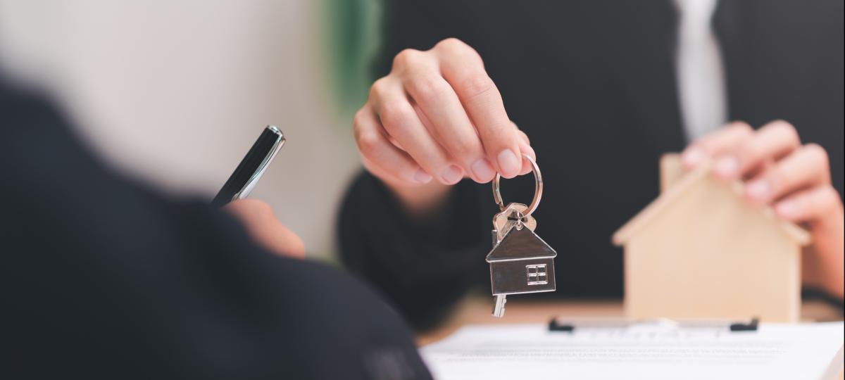 Agent broker trzymający domowy brelok do kluczy obsługuje dokumenty biznesowe i umowy podpisywanie umów biznesowych współpraca biznesowa podpisywanie handlowe podpisywanie umów umowa zakupu nieruchomości