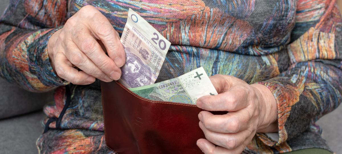 Emerytka licząca polskie banknoty 