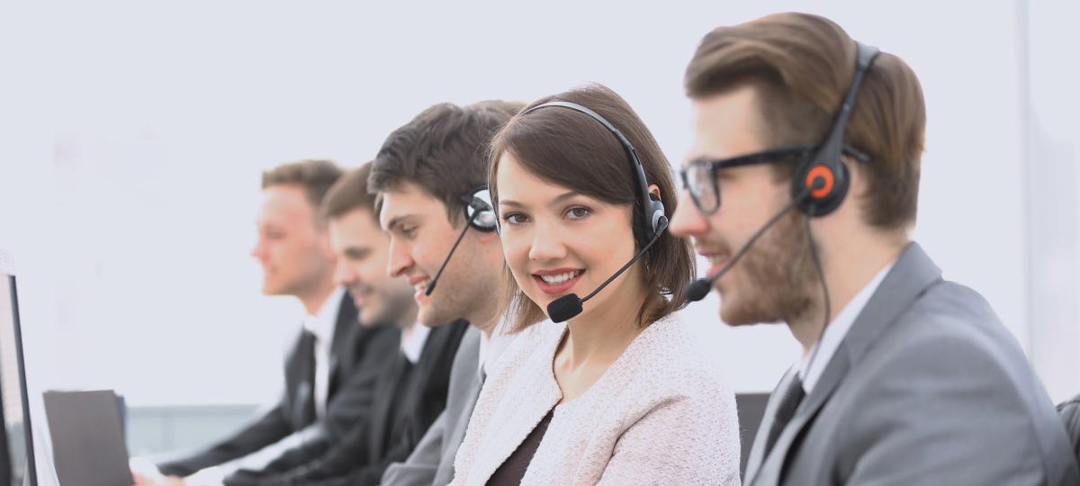 Centrum telefoniczne operatora z kolegami siedzącymi w miejscu pracy